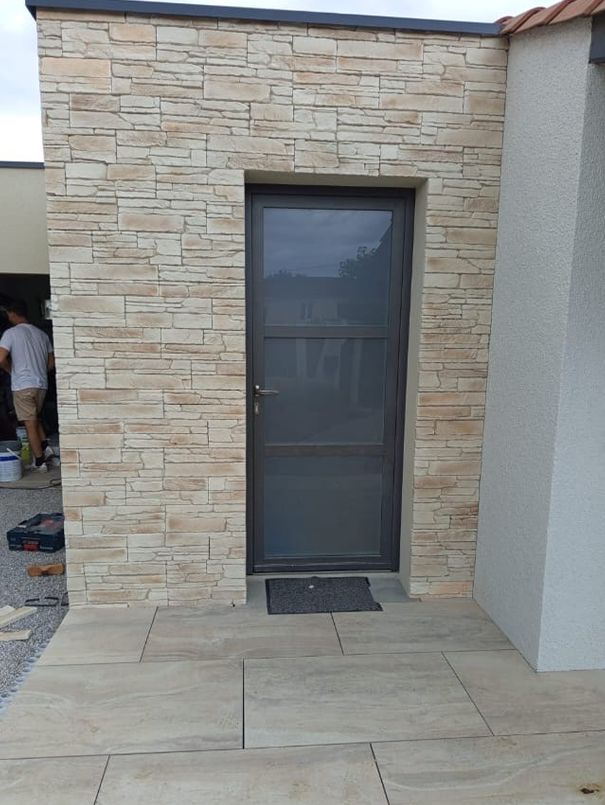 Extension terminée avec parement pierre et porte vitrée